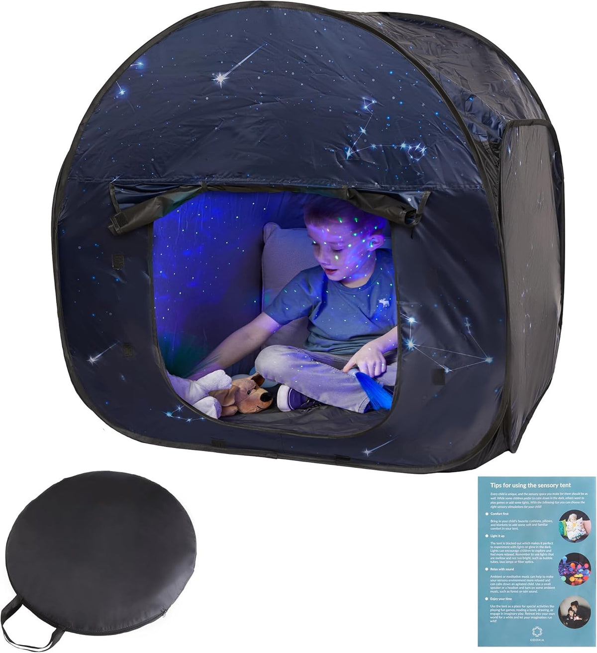 Child playing inside a dark tent with starry sky design, next to a carrying case and instruction sheet.