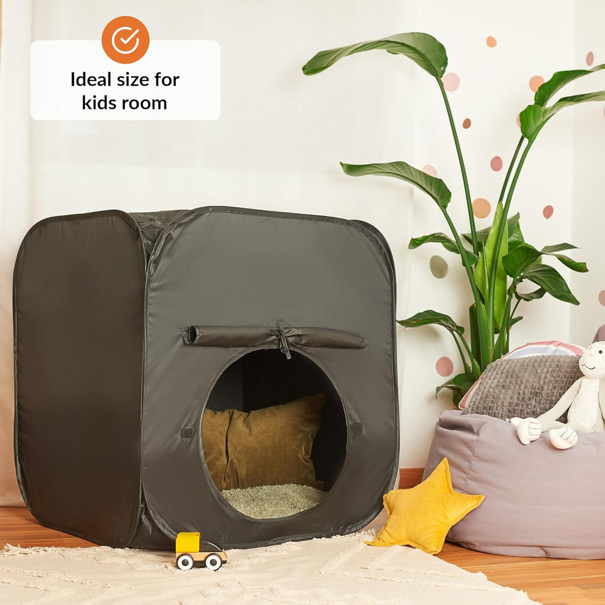 Pop-up sensory tent in a child's room with a plant and toys.