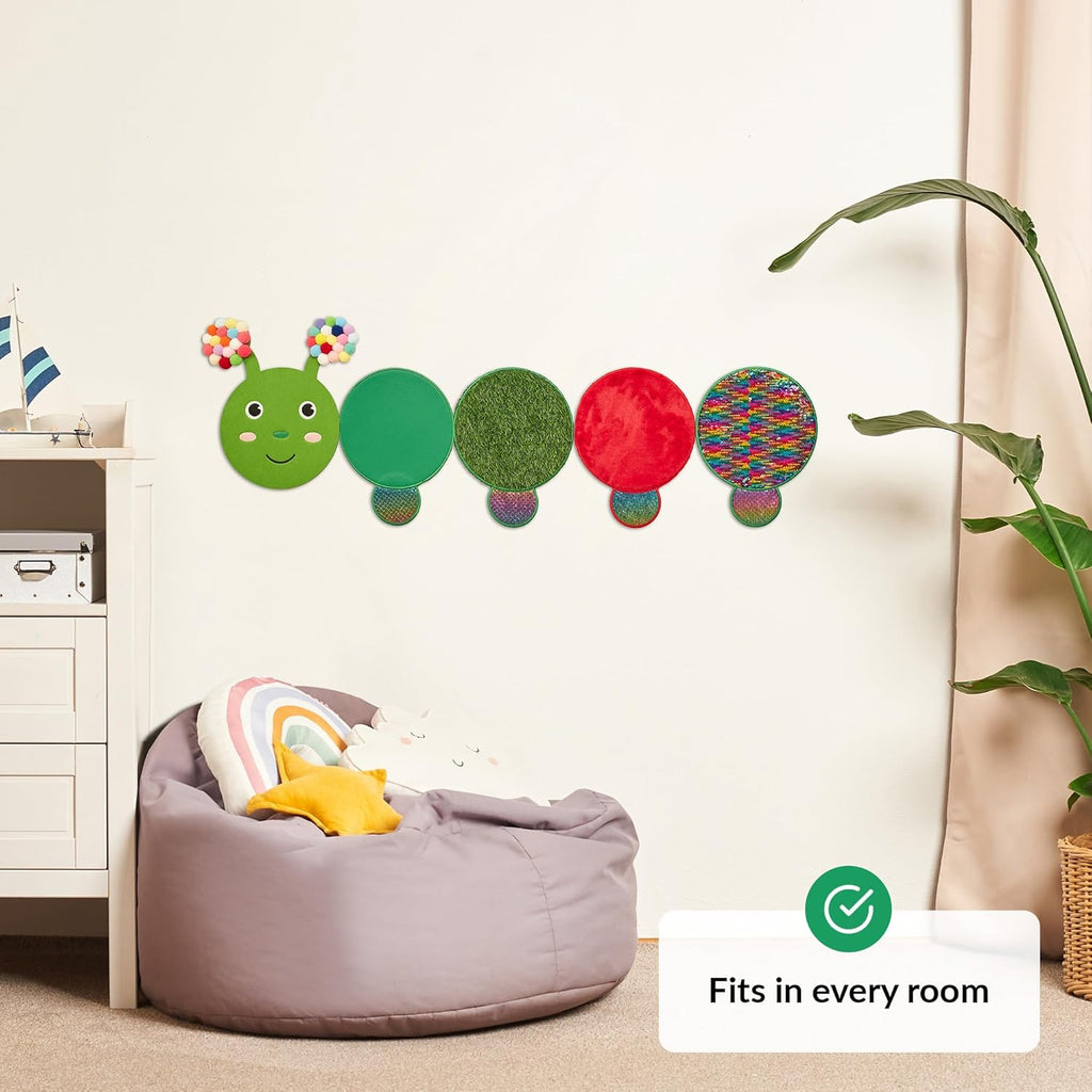 Colorful caterpillar wall decal above a bean bag chair in a room.