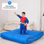 Child in superhero costume standing on a large blue mat with text 'Soft landings for every adventure' above.
