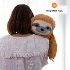 Person holding a weighted plush sloth toy with a white background