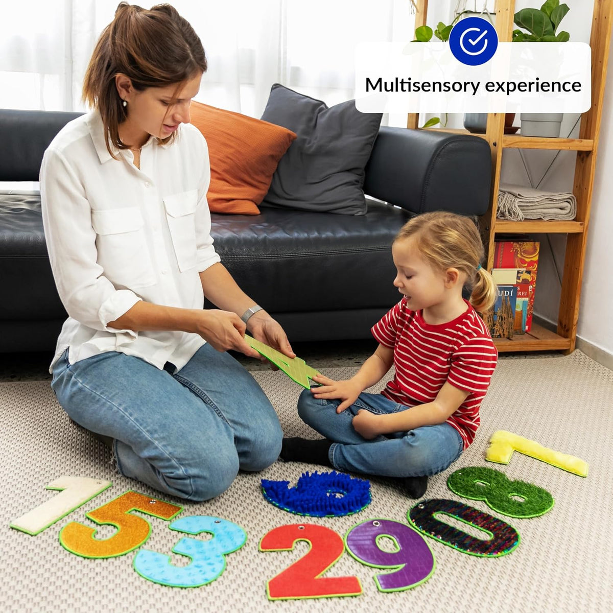 Woman and child playing with colorful number sensory toys on the floor.