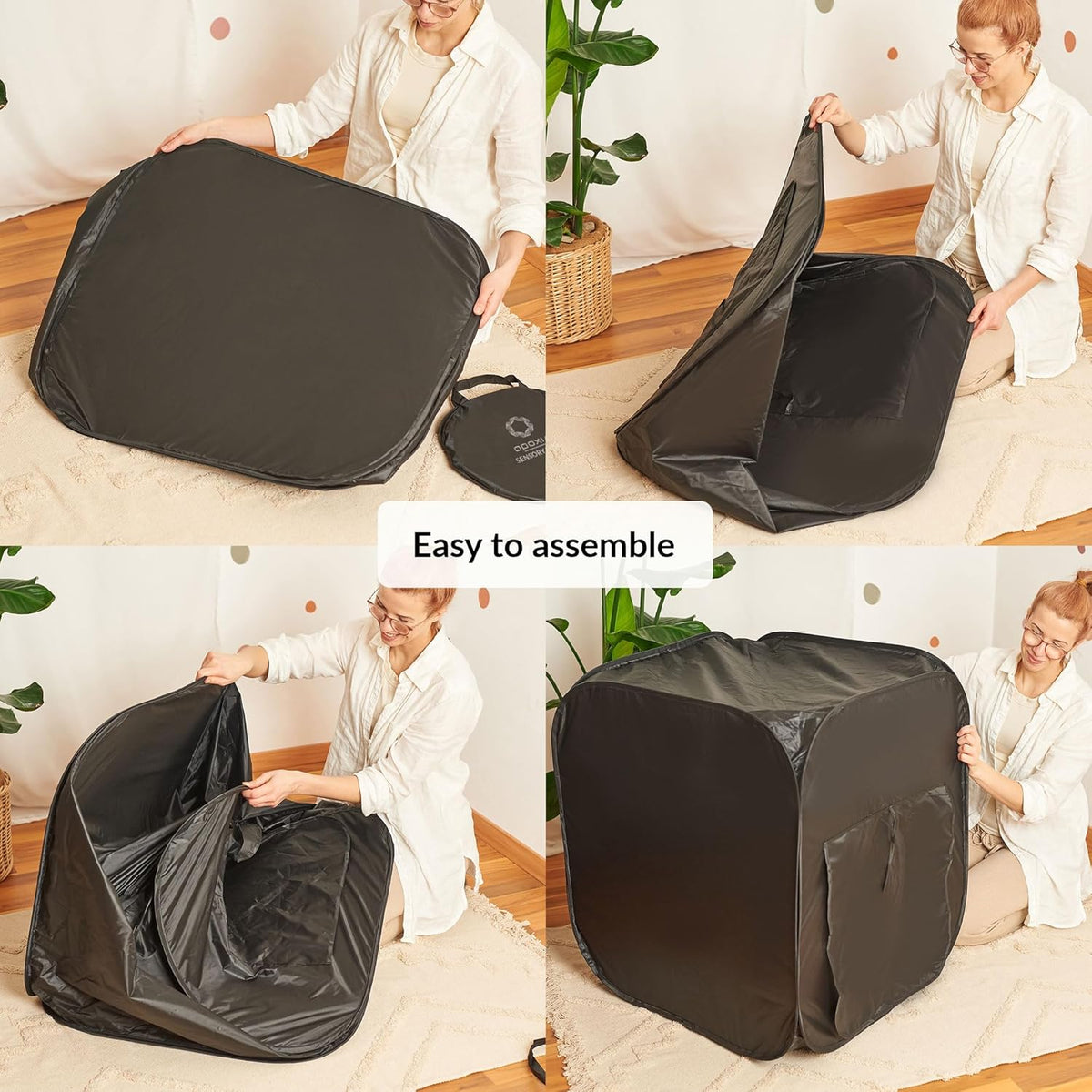 Person assembling a black pop-up tent in a room with plants and furniture.