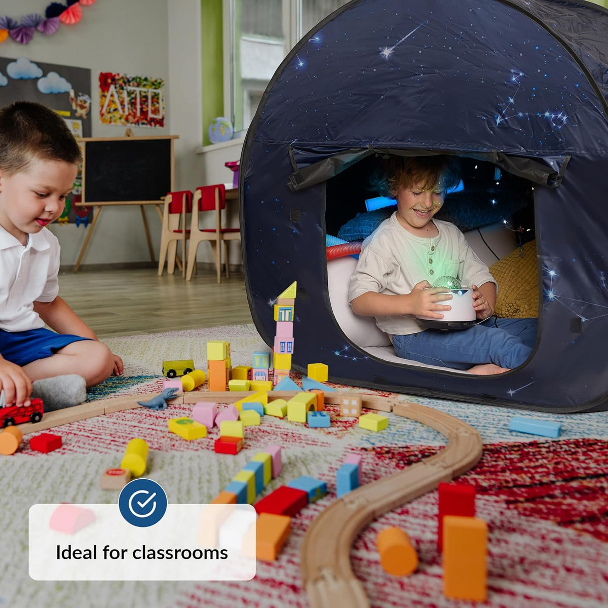 Child playing with toys inside a sensory tent in a classroom setting