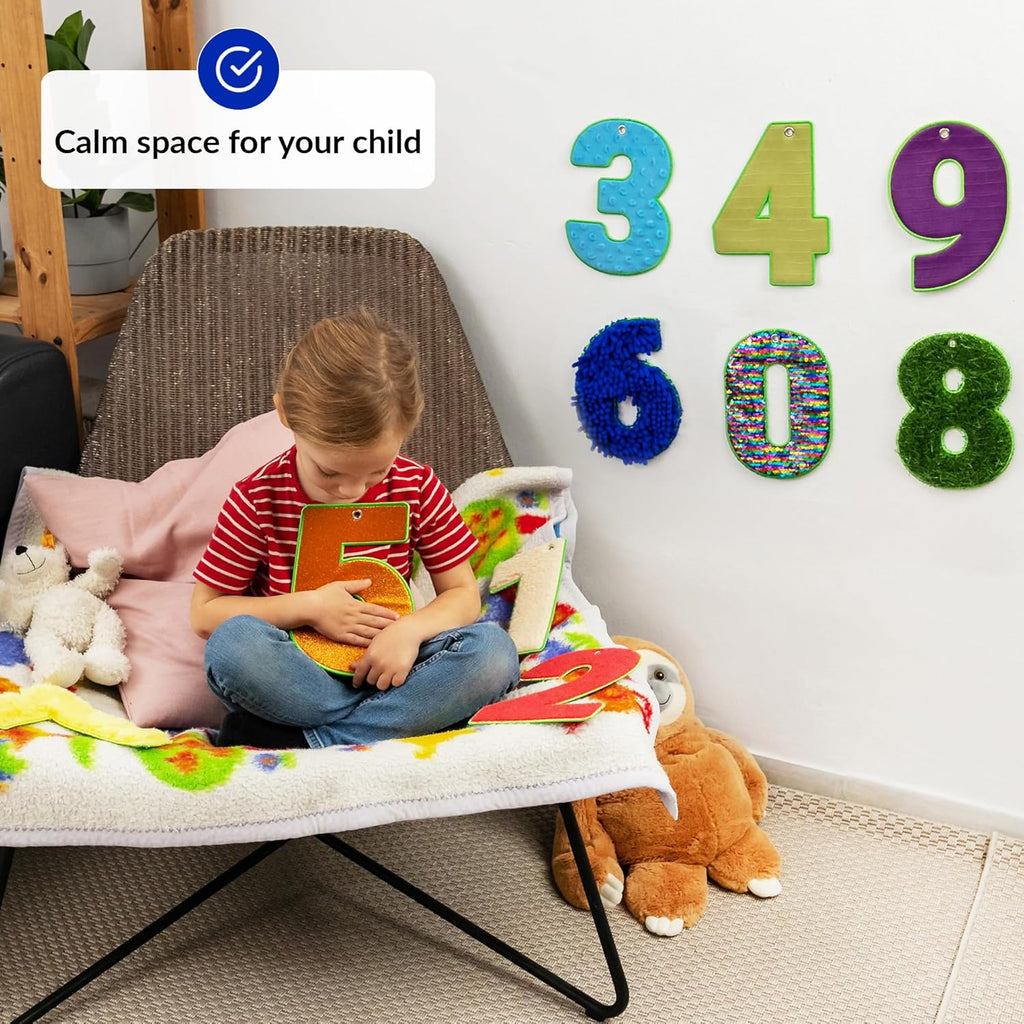 Child playing with sensory number with decorative numbers on the wall.