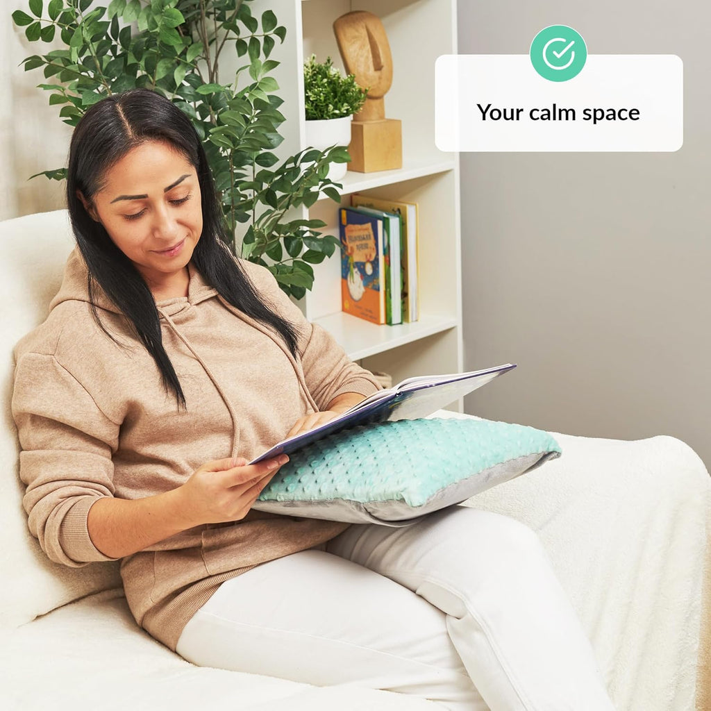 Woman reading a book on a couch with sensory pillow.