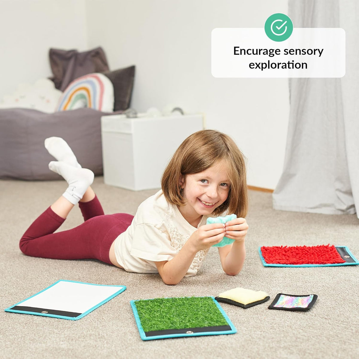 Child playing with colorful mats on the floor, encouraging sensory exploration.