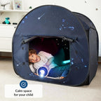 Child playing inside a dark blue tent with star patterns, holding a glowing toy.