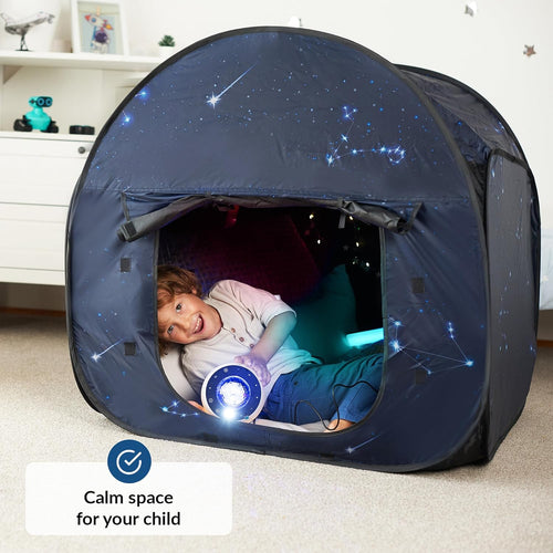 Child playing inside a dark blue tent with star patterns, holding a glowing toy.