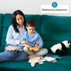 Woman and child sitting on a teal couch with educational materials and a panda plush toy, labeled 'Multisensory experience'.