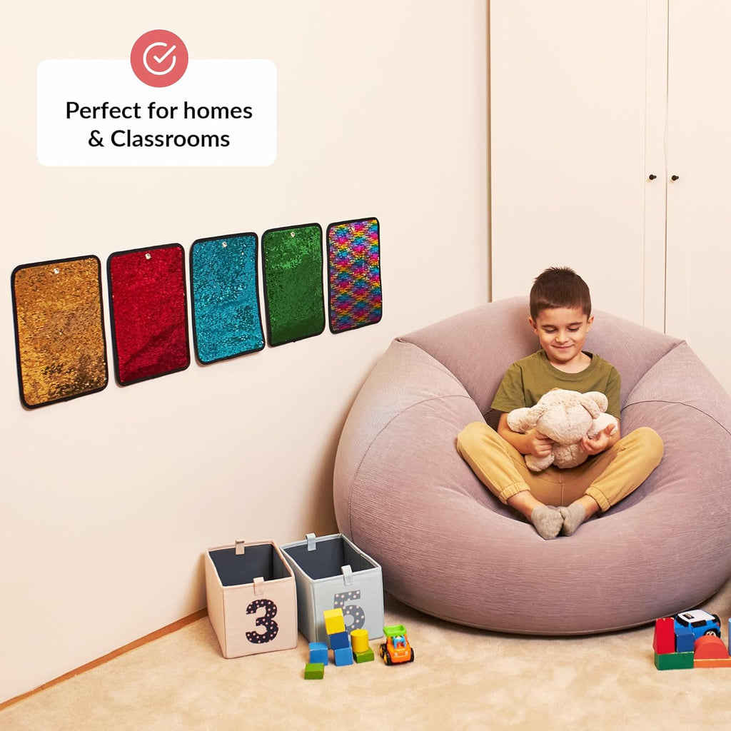 Child sitting on a bean bag with toys, surrounded by colorful wall sensory decorations.