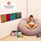 Child sitting on a bean bag with toys, surrounded by colorful wall sensory decorations.
