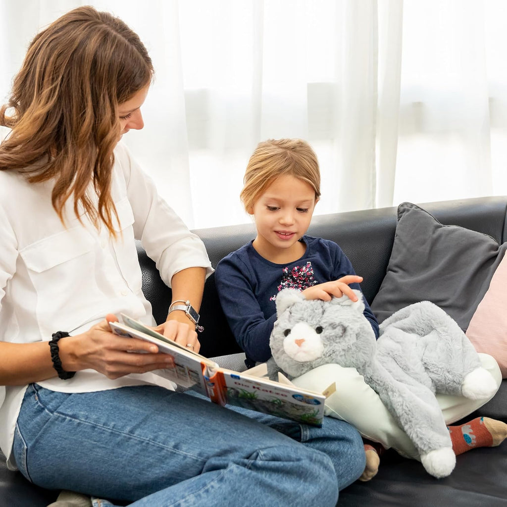 Woman reading a book to a child on a couch with a weighted lap cat