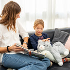 Woman reading a book to a child on a couch with a weighted lap cat