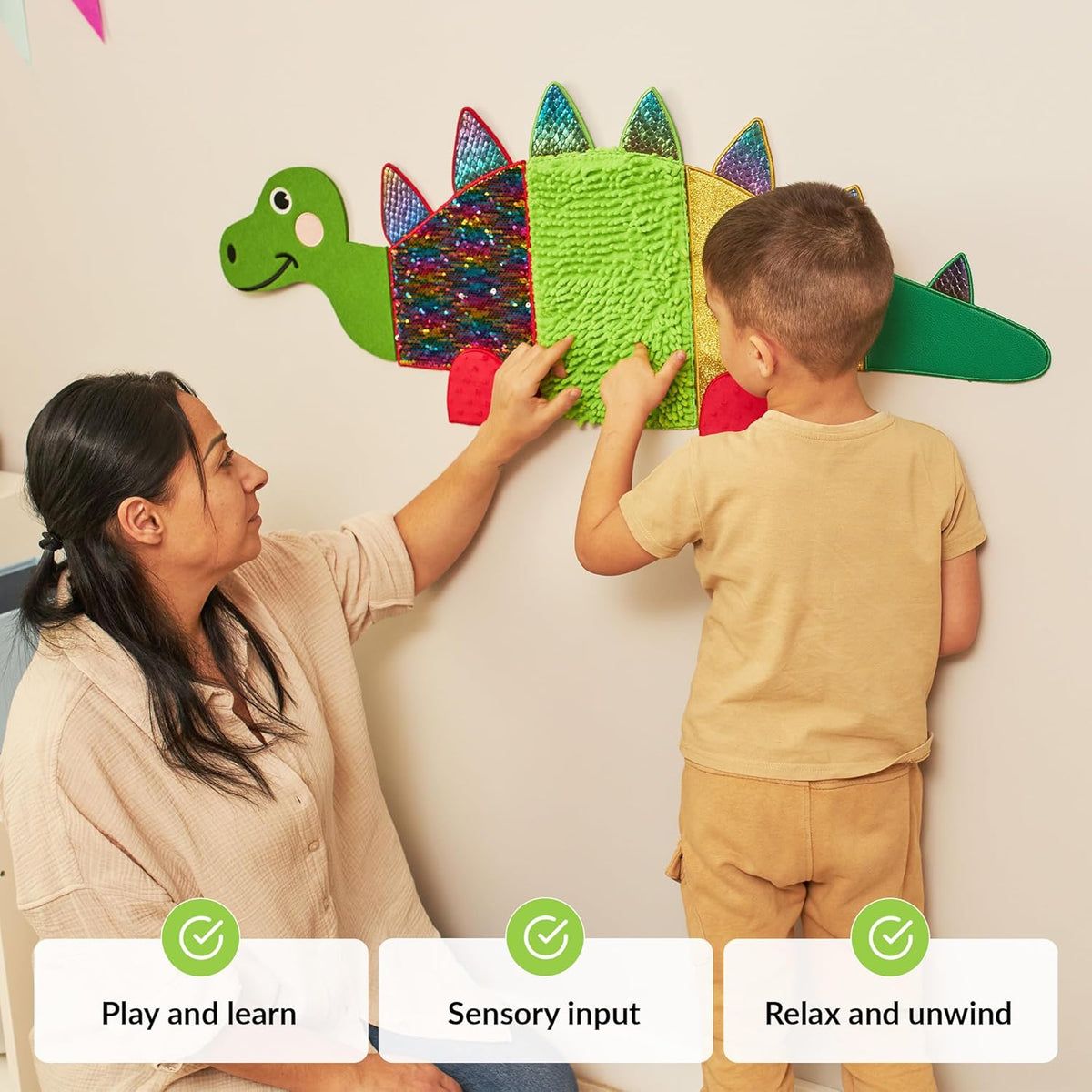 Mother and autistic child interacting with a colorful dinosaur-shaped wall toy, with text indicating benefits.