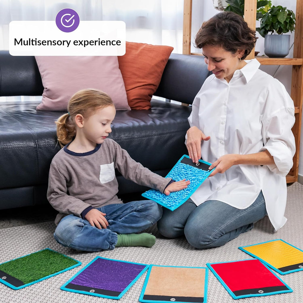 Woman and child playing with colorful sensory mats on the floor, with a focus on a multisensory experience.