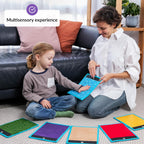 Woman and child playing with colorful sensory mats on the floor, with a focus on a multisensory experience.