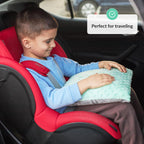 Child sitting in a red car seat holding a green pillow with text 'Perfect for traveling'.