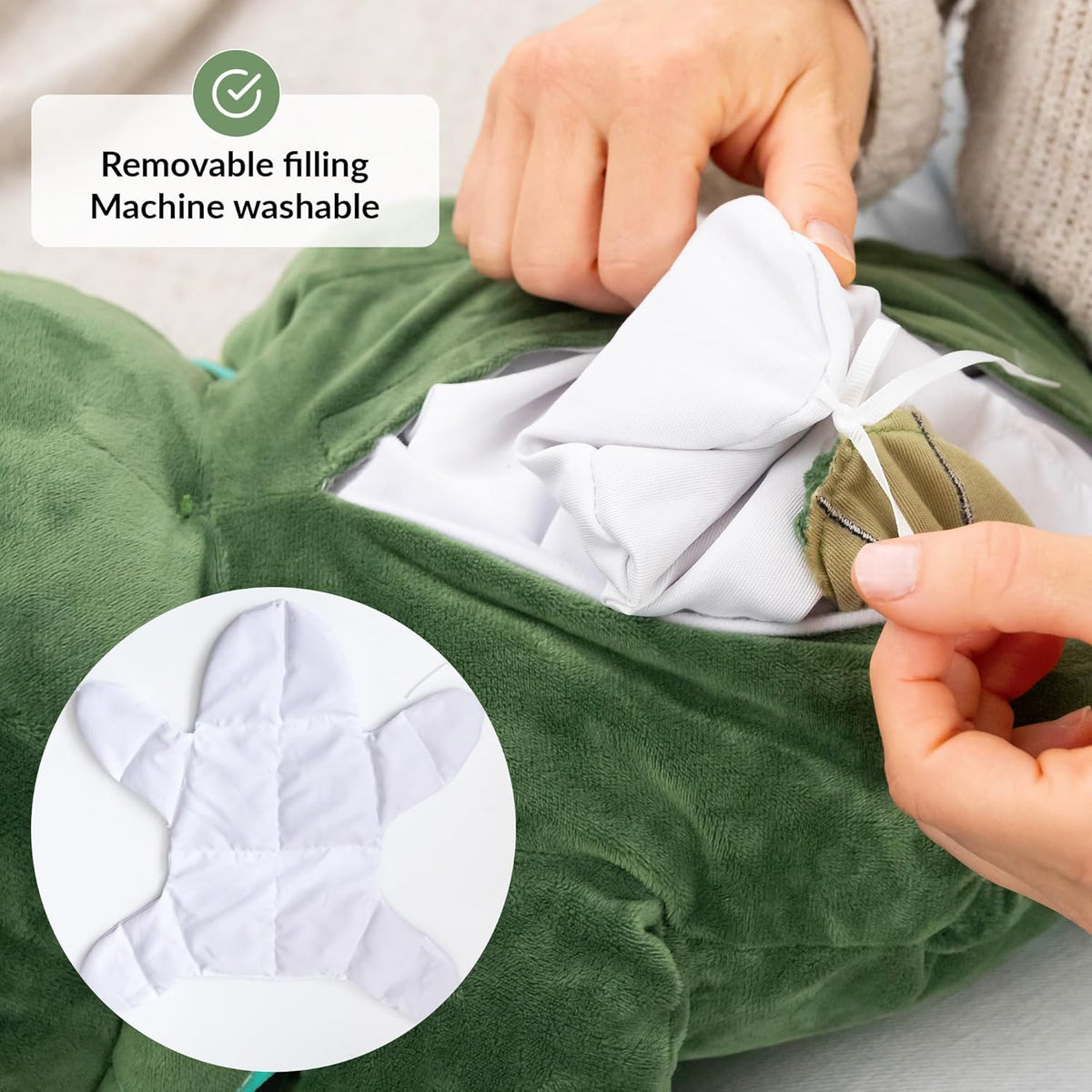 Green dino plush toy with a hand removing a white filling, labeled 'Removable filling Machine washable'.