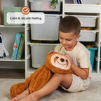 Child holding a plush sloth toy