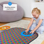 Child playing with a colorful sequins mat on the floor.