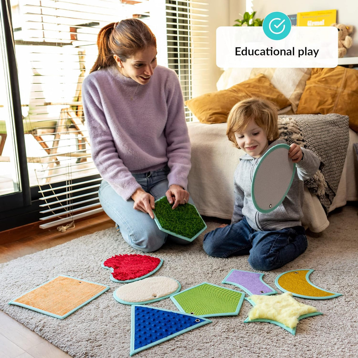 Woman and child playing with colorful educational toys on a carpeted floor.