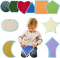 Child playing with colorful textured mats of different shapes on a white background