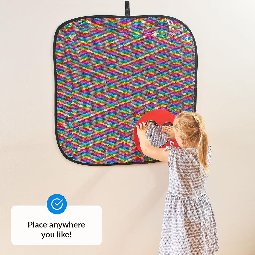 Child playing with a colorful patterned wall panel on a wall