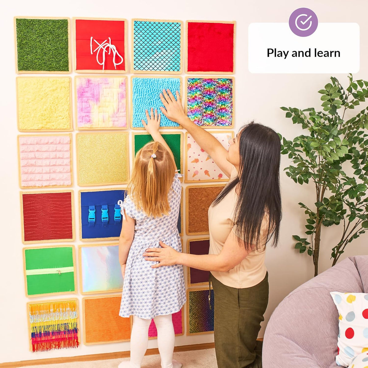 Woman and child interacting with a colorful wall panel display.